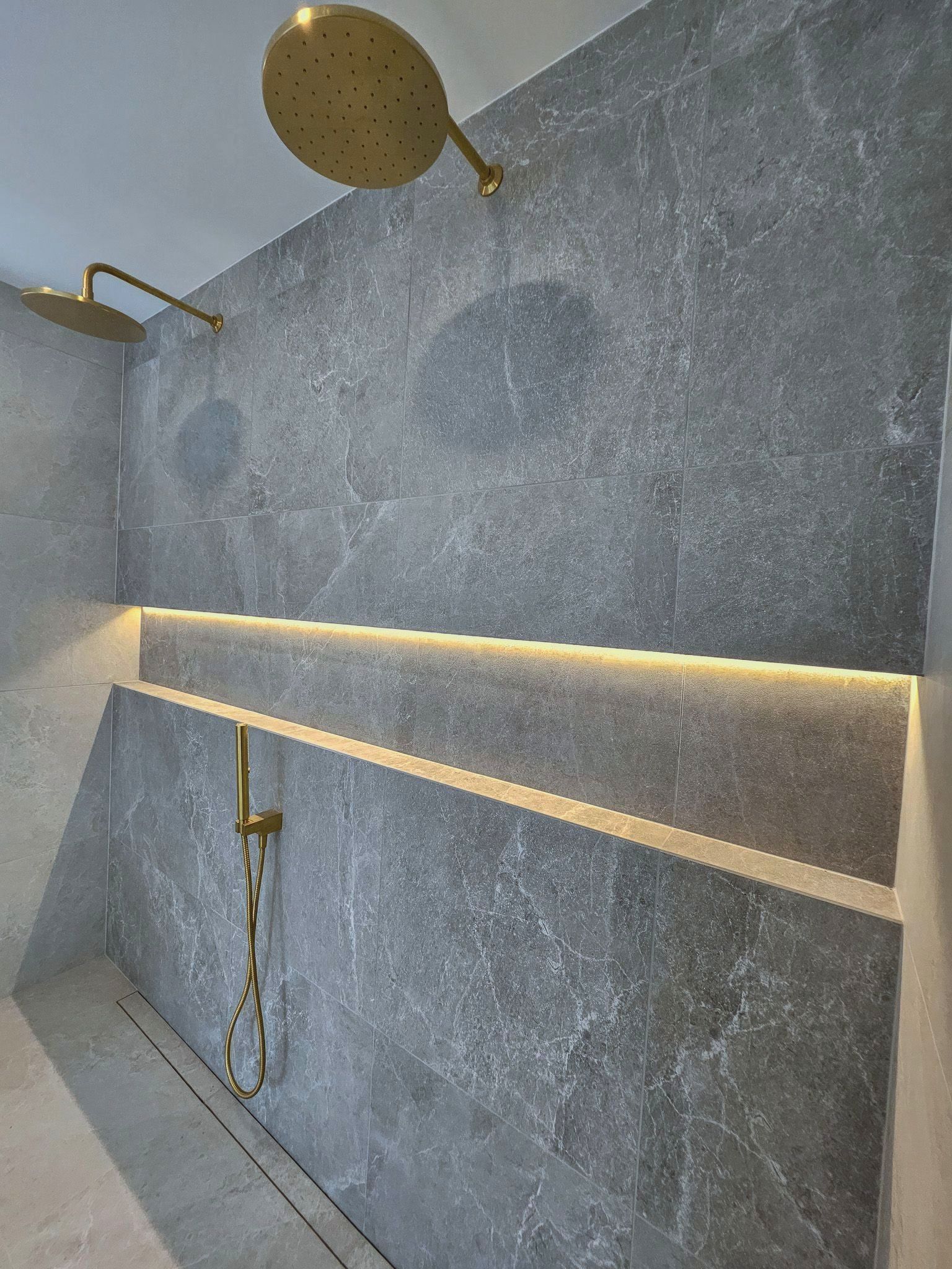 A bathroom with a shower head hanging from the wall.