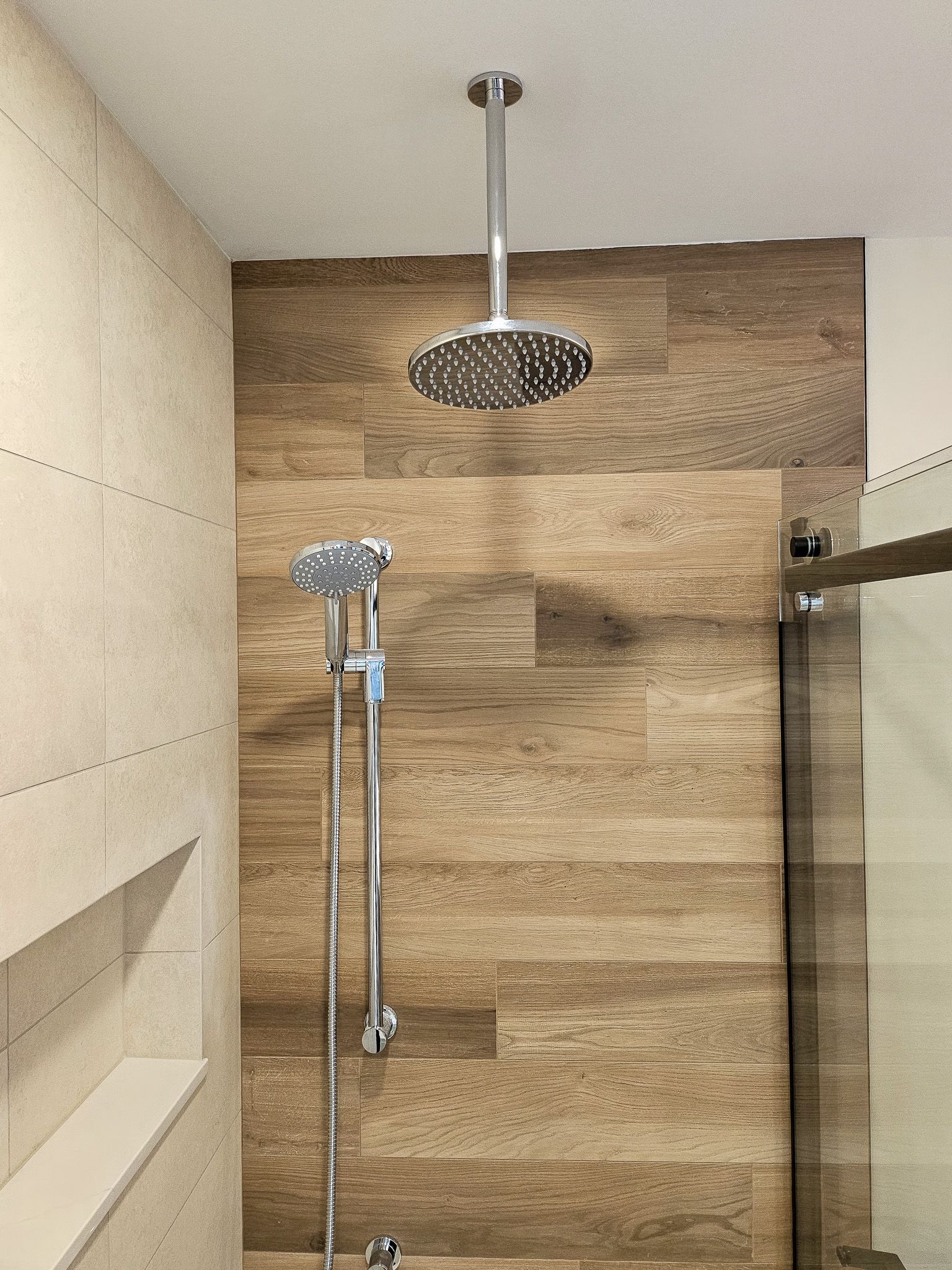 A shower head is hanging from the ceiling in a bathroom