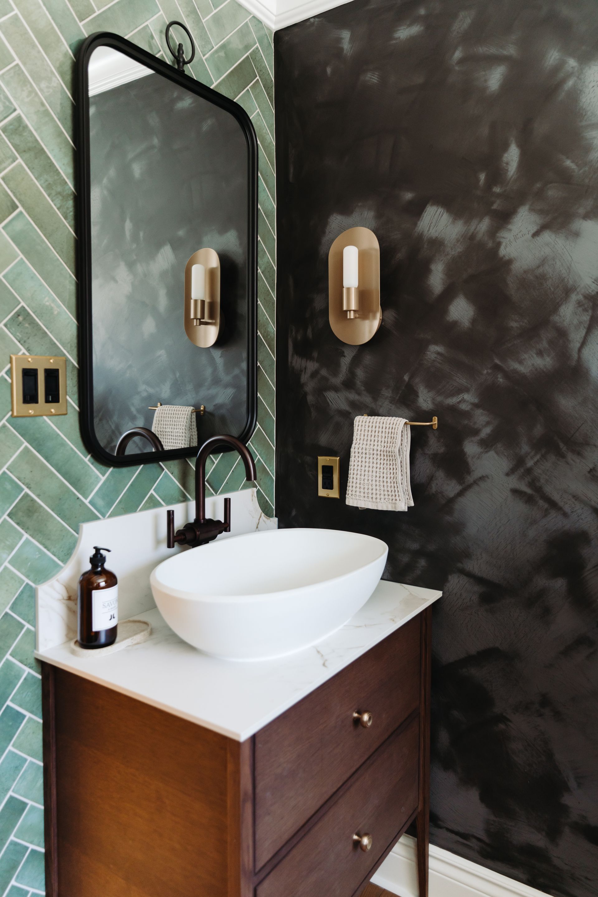 Une salle de bain avec un lavabo et un miroir au mur.