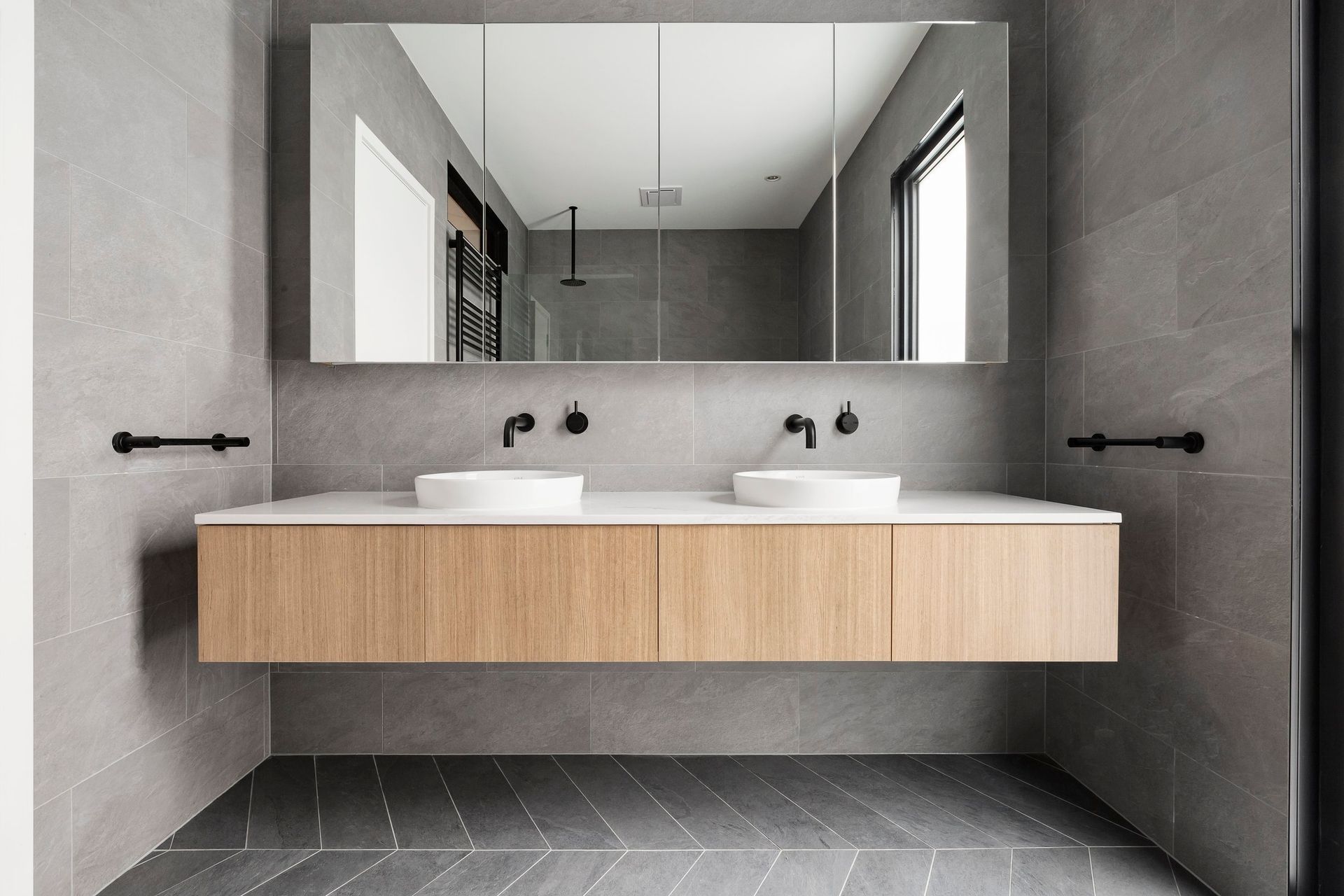 A bathroom with two sinks and a large mirror.