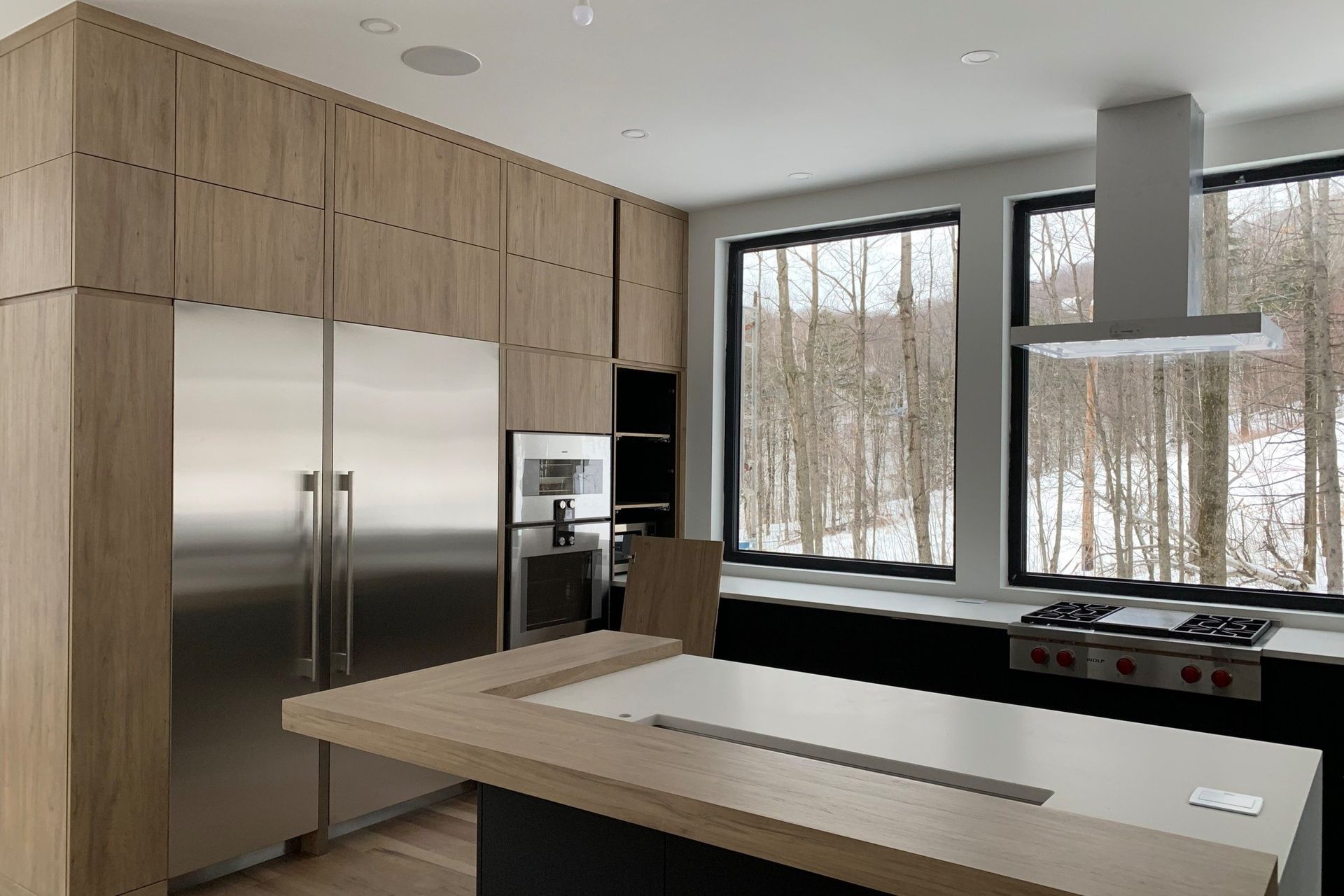 A kitchen with stainless steel appliances , wooden cabinets and a large island.