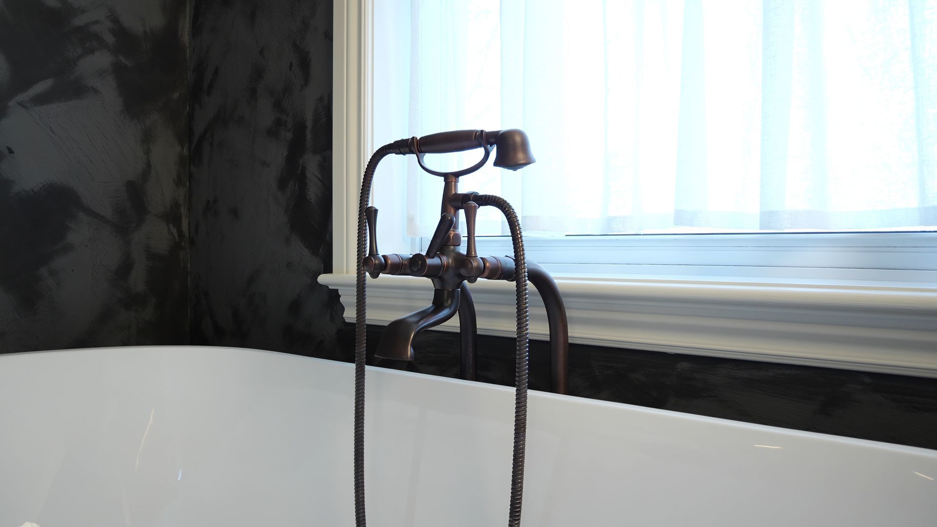 A bathtub with a faucet attached to it and a window in the background.