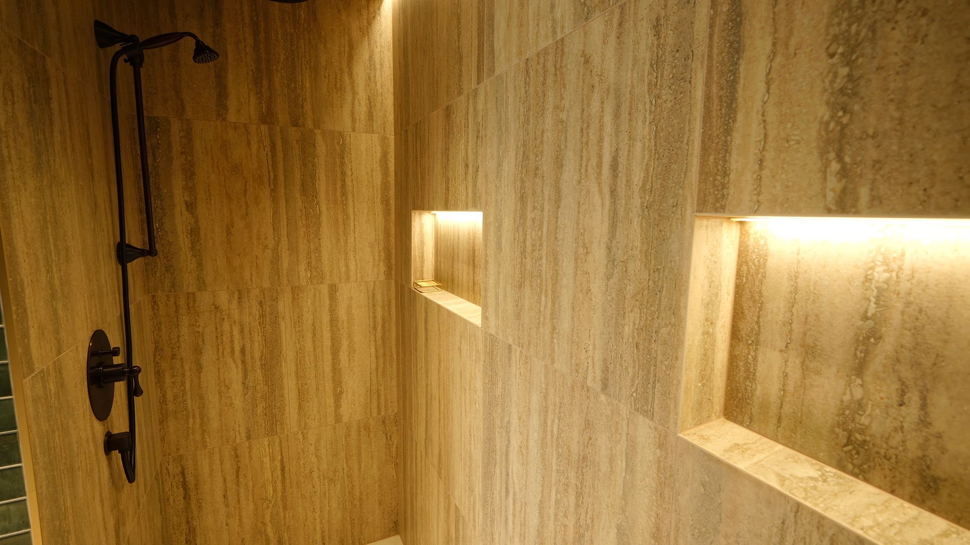 A bathroom with a shower and two niches in the wall.