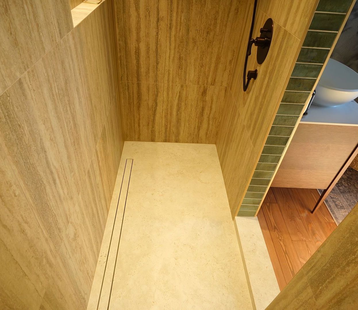 A bathroom with a walk in shower and a sink