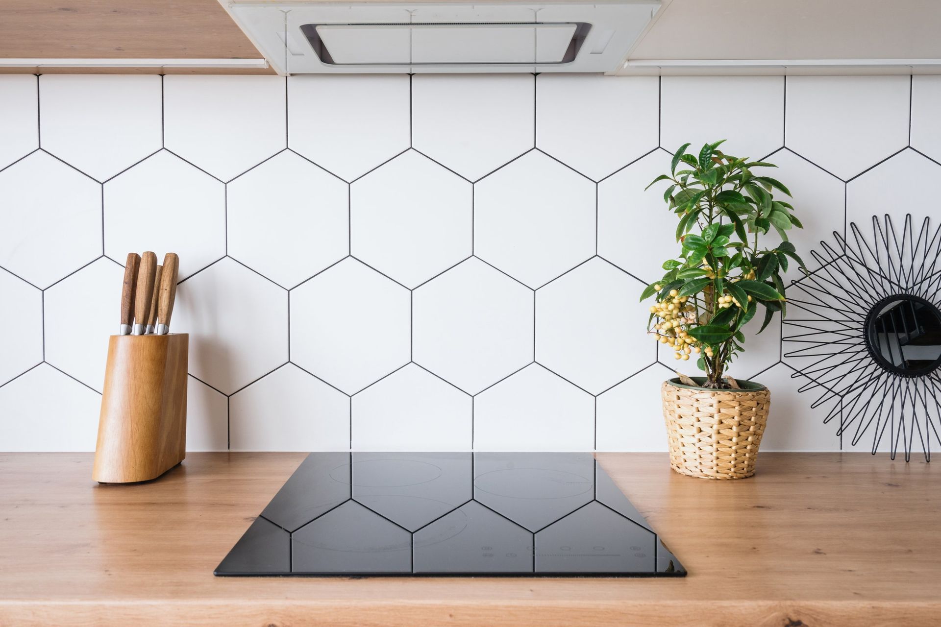 A black stove top oven is sitting on a wooden counter in a kitchen.