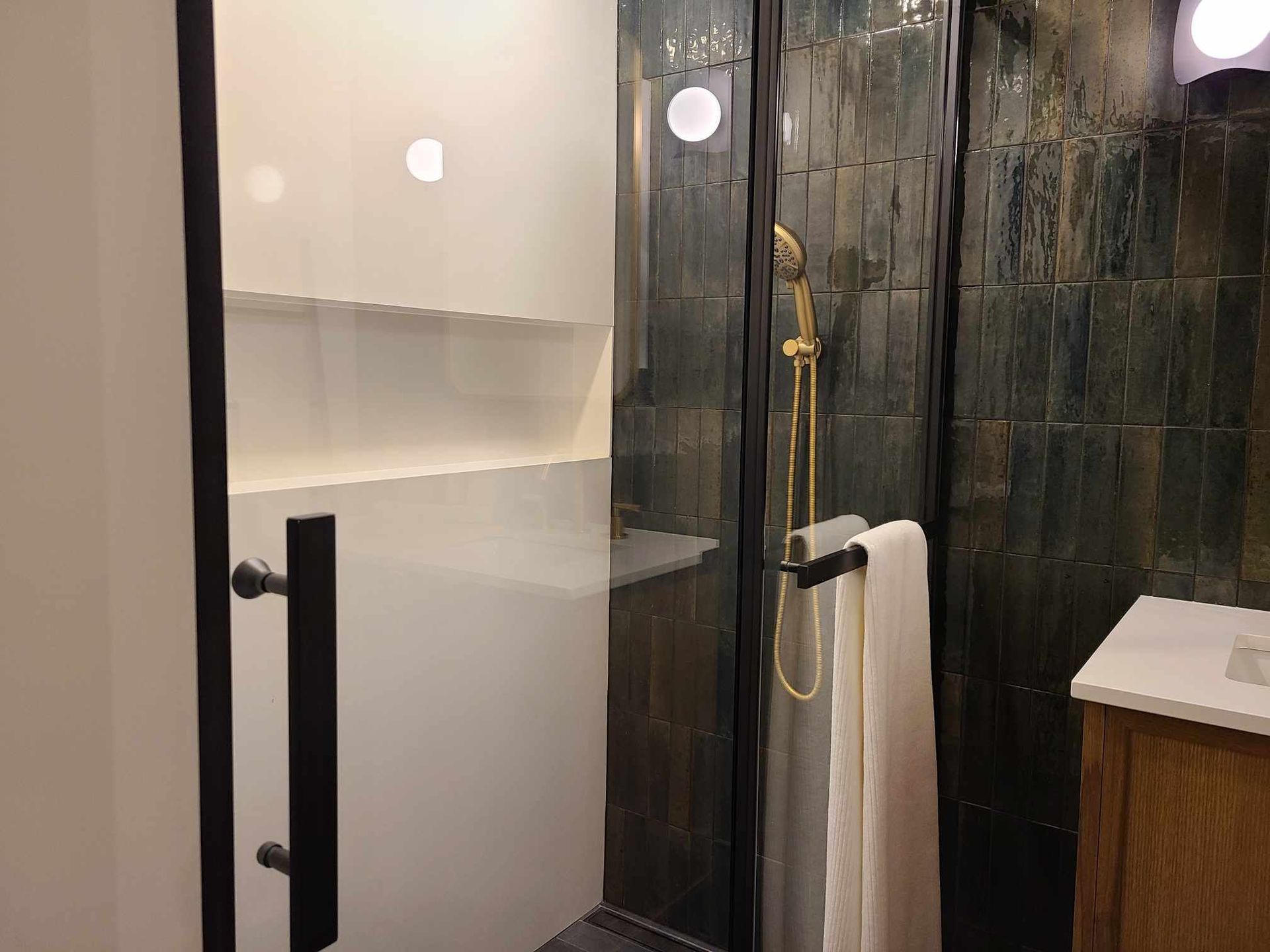 A bathroom with a walk in shower and a sink.