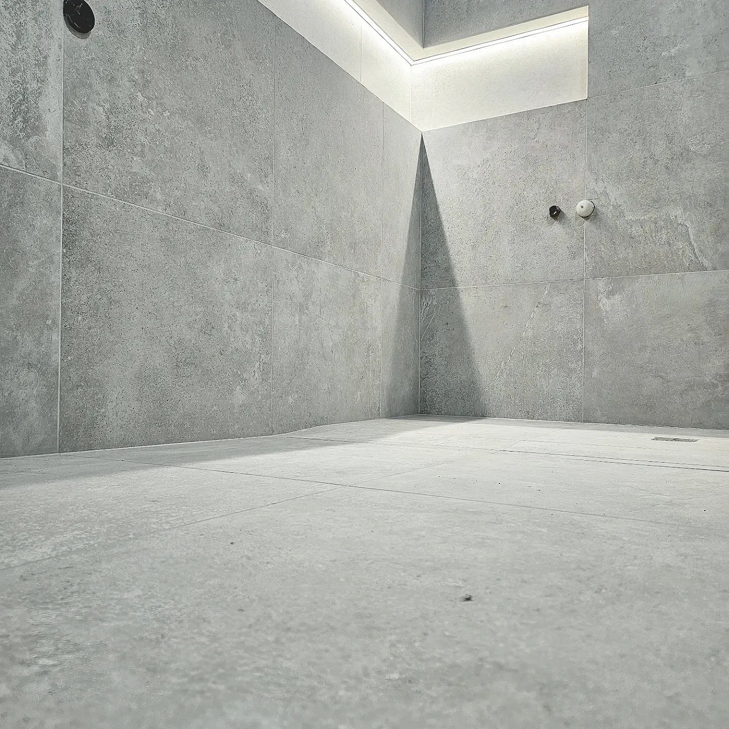 A corner of a room with a concrete floor and walls
