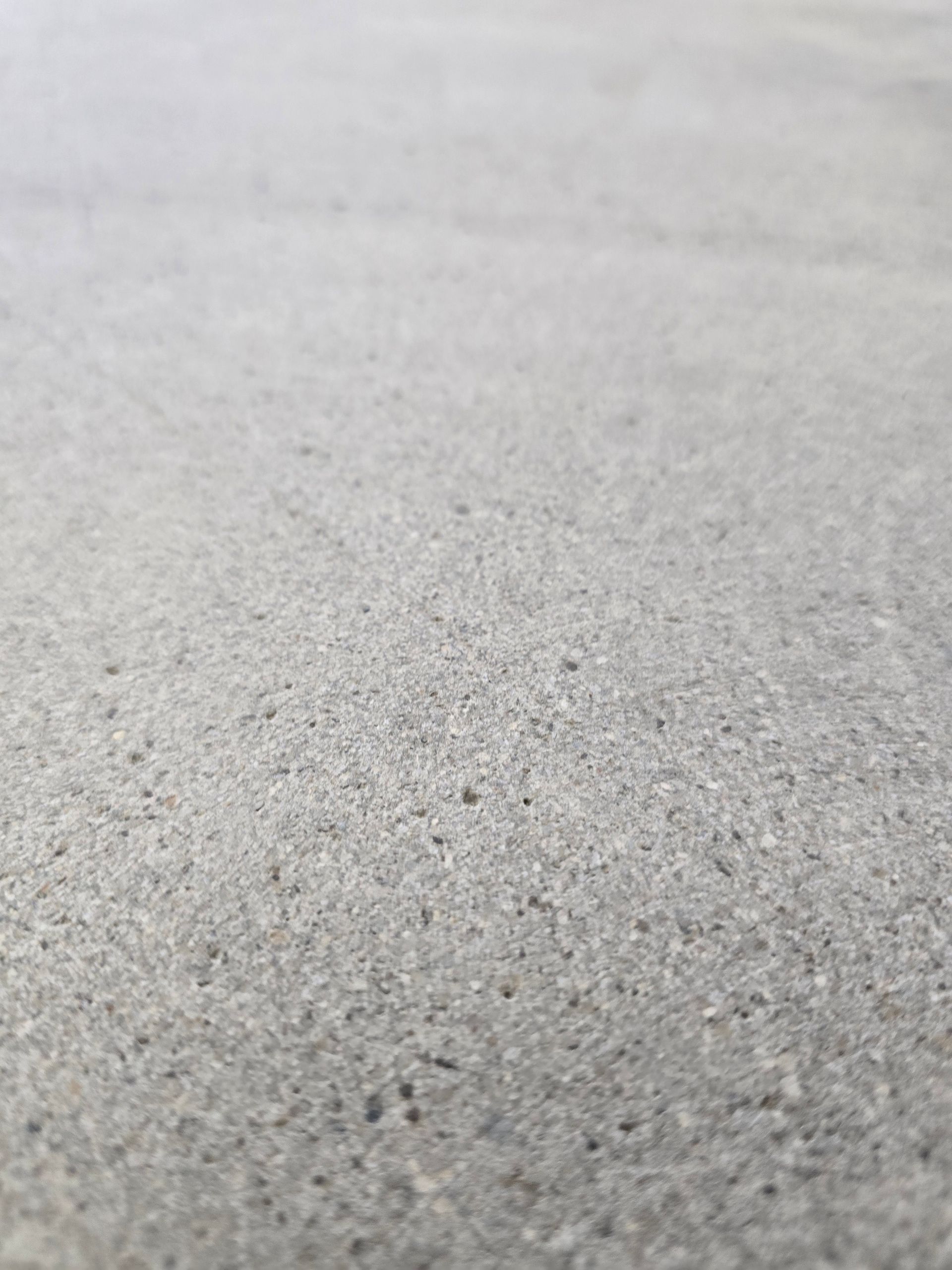 Close-up of a gray, rough concrete surface with a blurred background