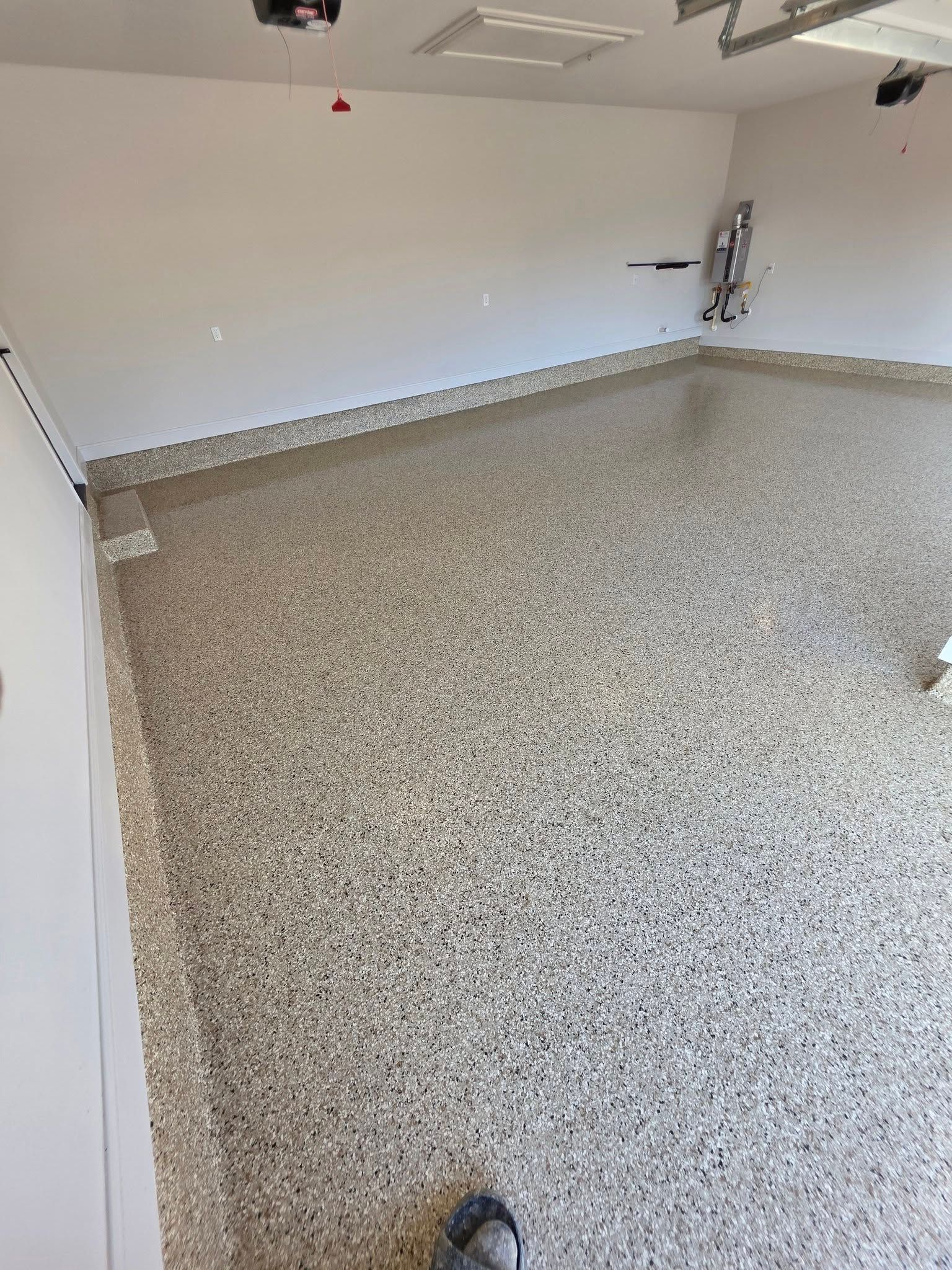 Empty garage with speckled epoxy floor and white walls