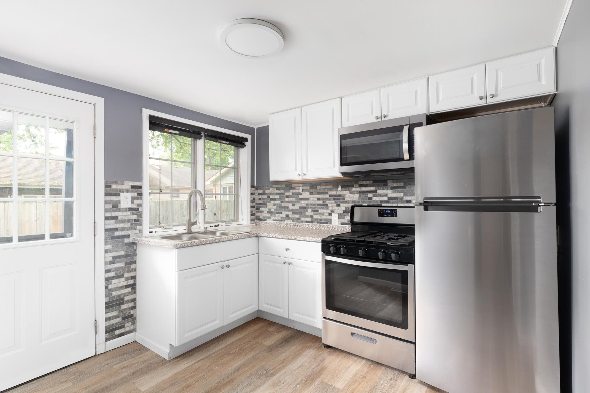 A kitchen with stainless steel appliances and white cabinets