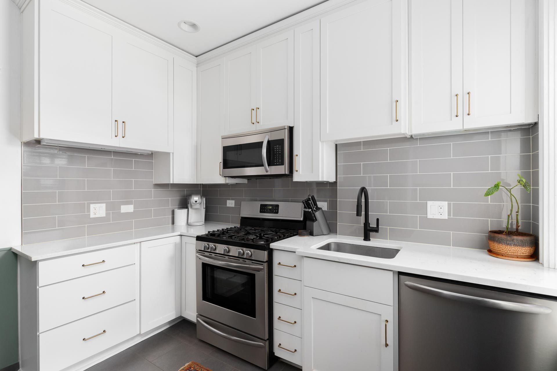 A kitchen with white cabinets and stainless steel appliances.