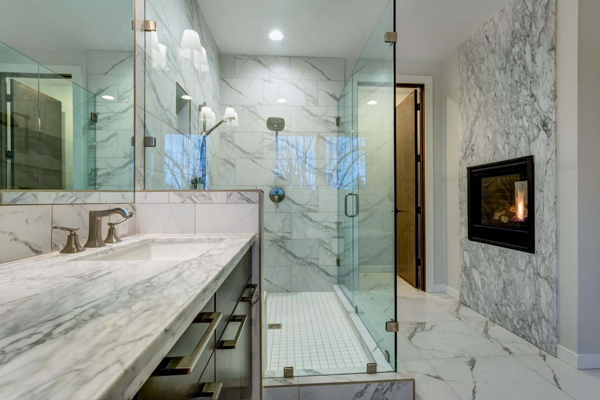 A bathroom with a walk in shower and a fireplace.