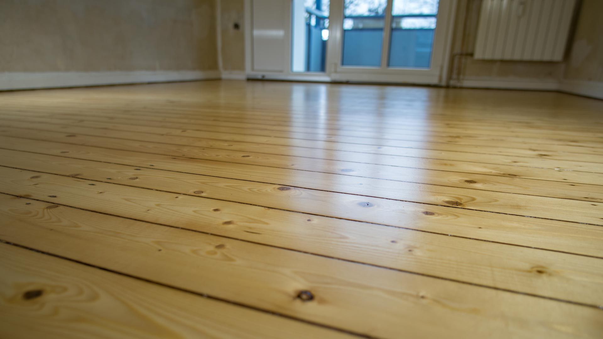 A person is laying a tile floor with a hammer.