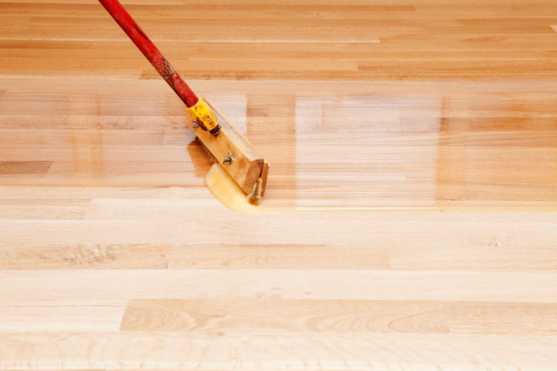 A person is laying a tile floor with a hammer.