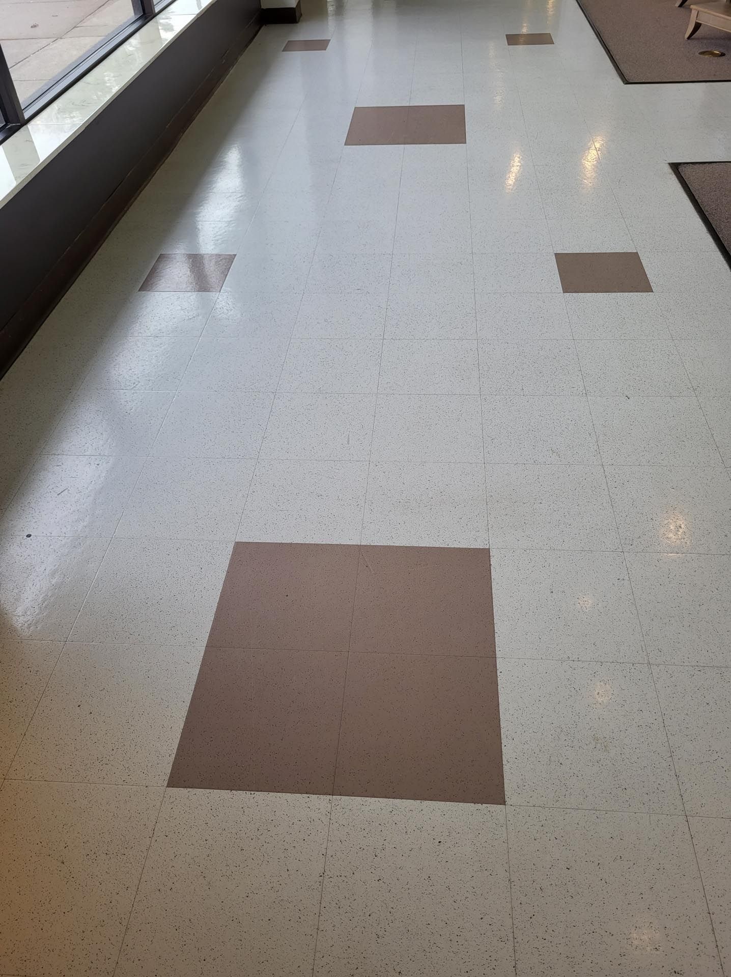 A row of yellow tiles on a gray tiled floor.