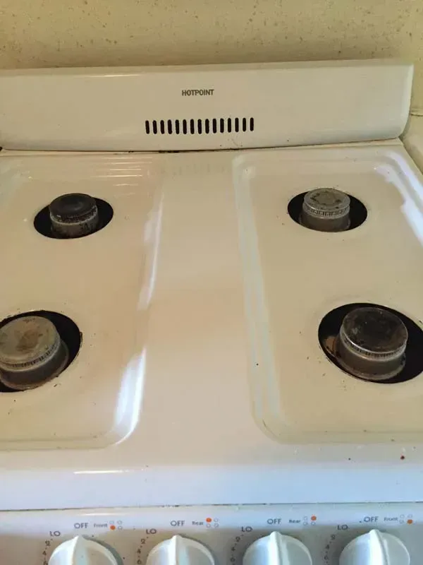 White four-burner gas stovetop with black burner rings and a back control panel.