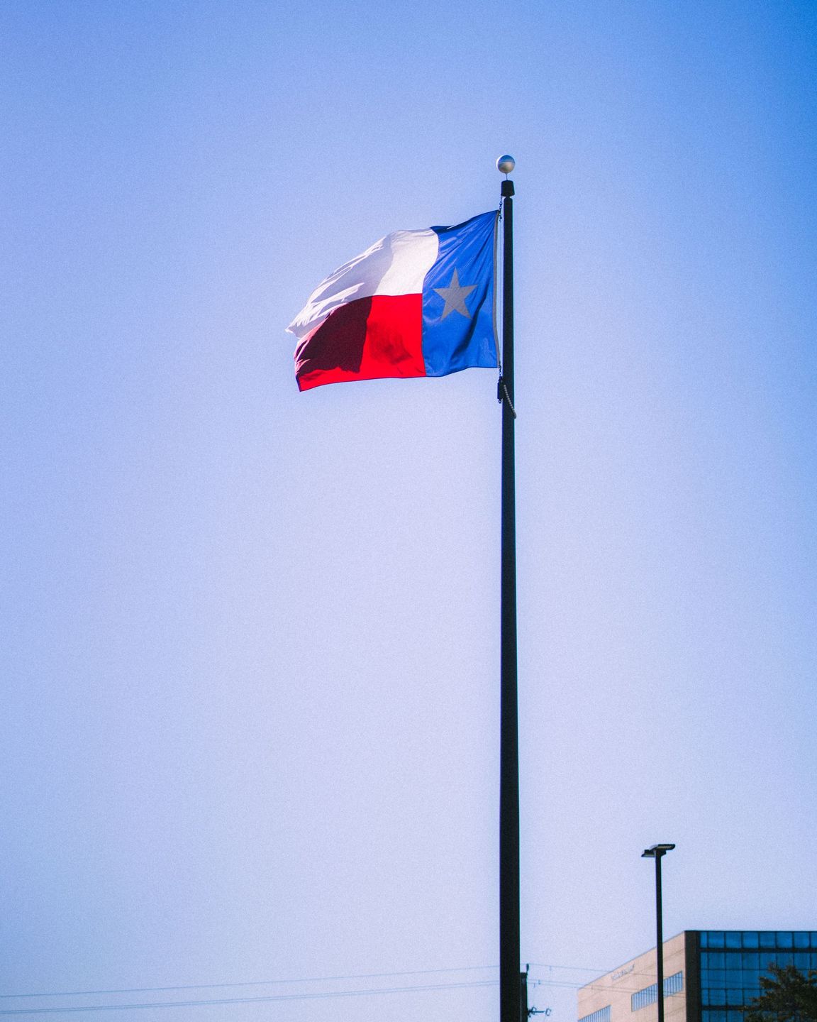 A river runs through a park surrounded by trees on a sunny day.