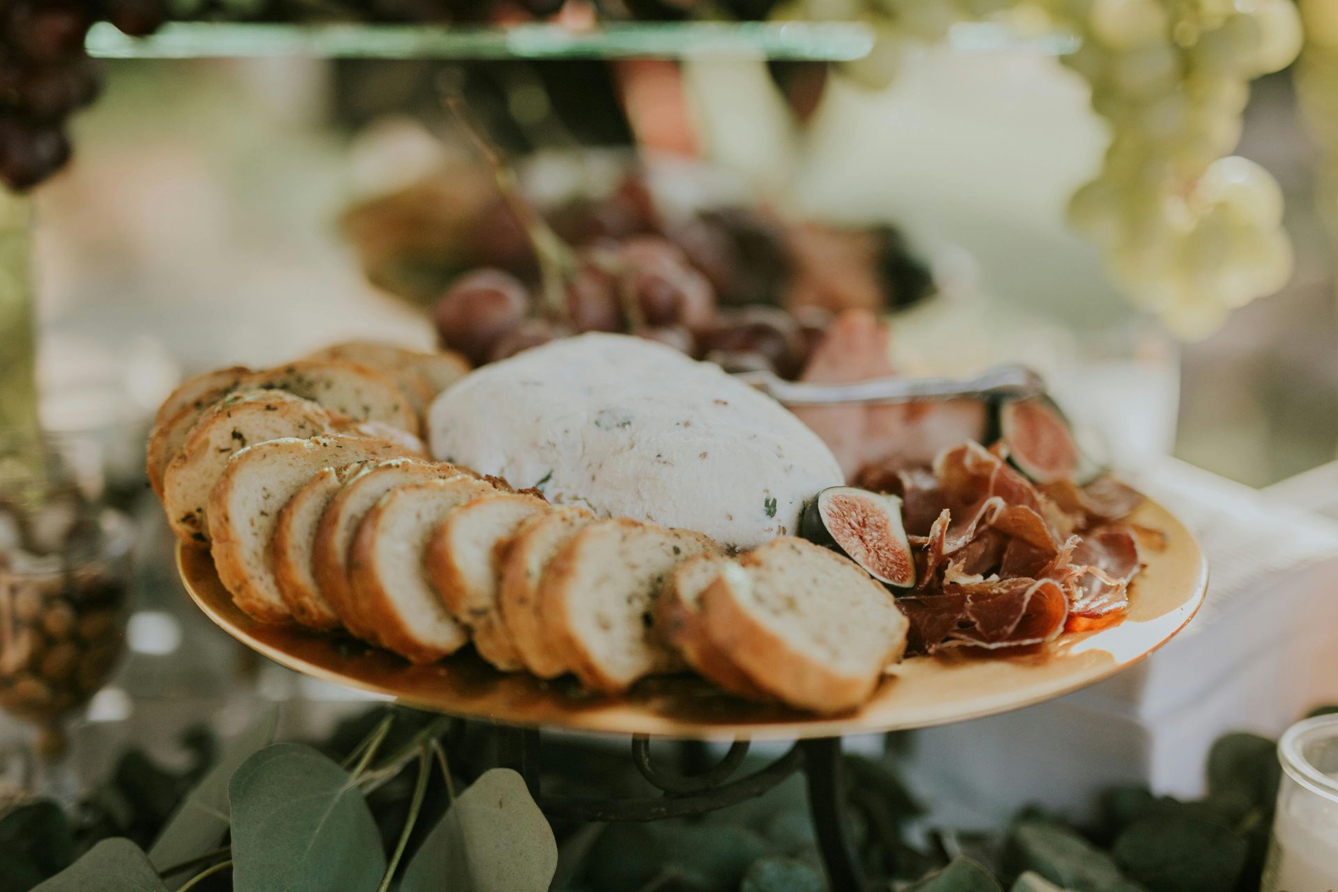 Du pain tranché et de la charcuterie sur un plateau avec une meule de fromage ronde