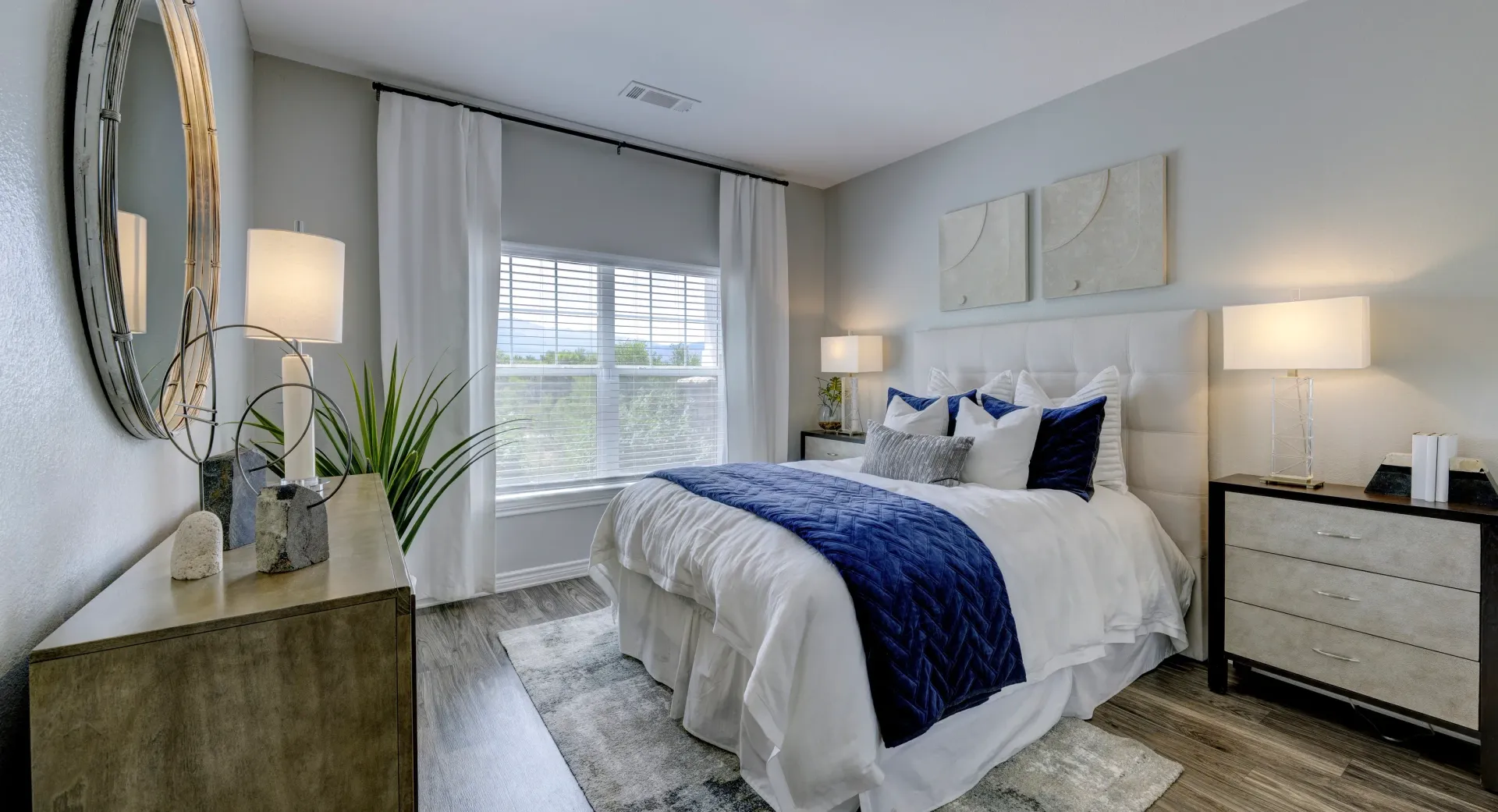 A bedroom with a king-size bed, dresser, and mirror.