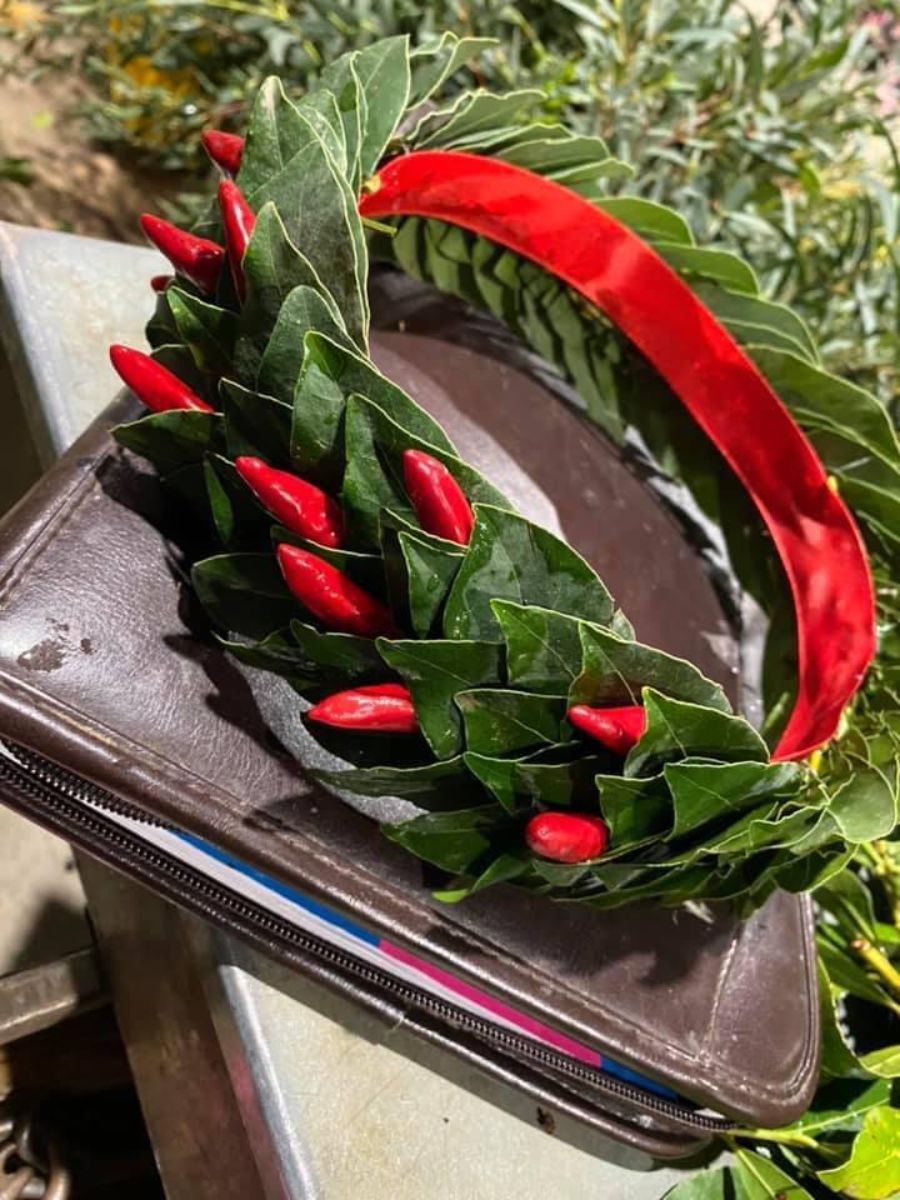 corona d'alloro con nastro rosso e peperoncini