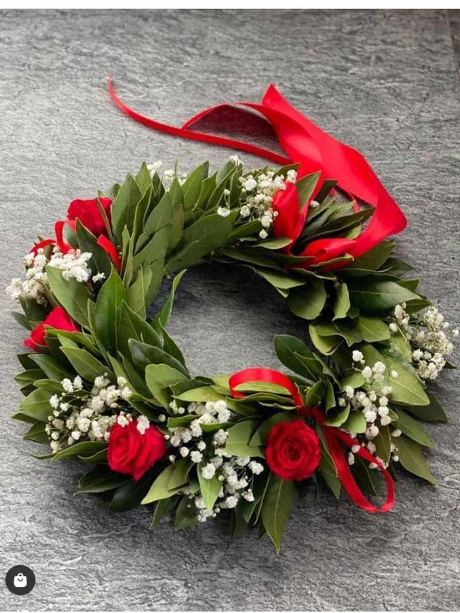 corona d'alloro con rose rosse e nastro rosso