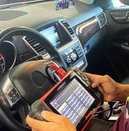 A person is holding a tablet in their hand in a car. | Elite Auto Experts