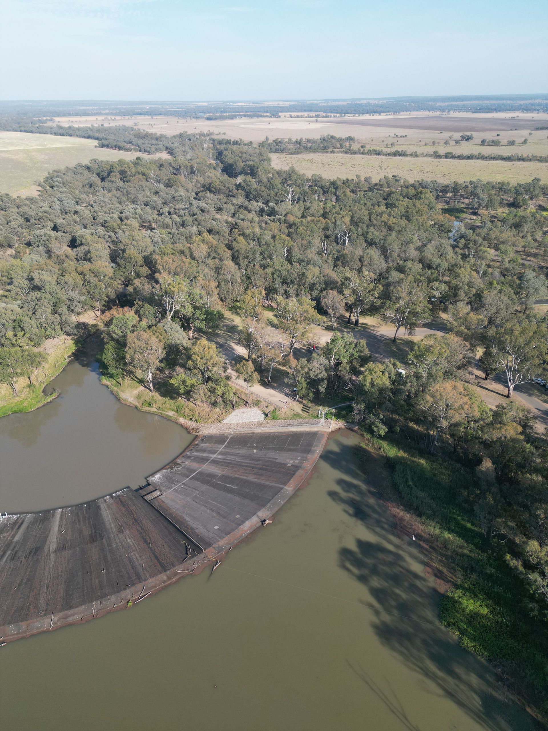 An aerial view of a lake surrounded by trees and fields.