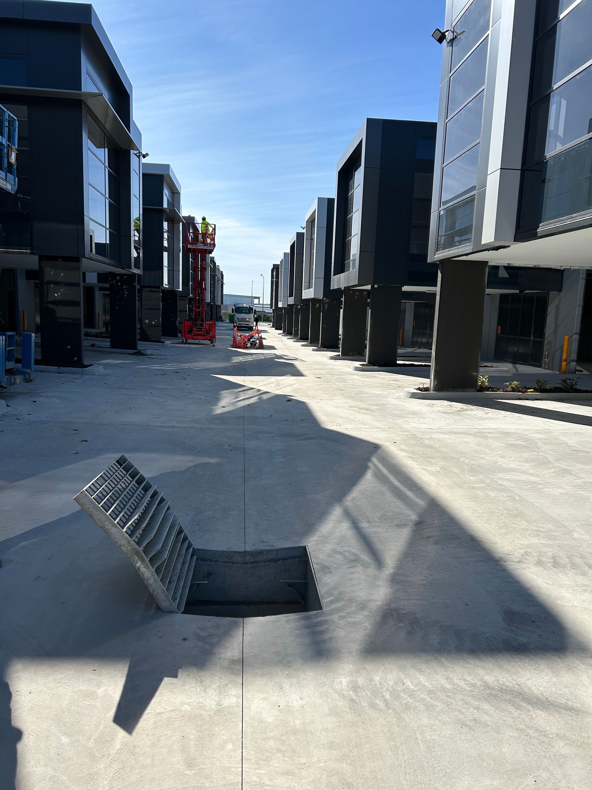 A large pipe is sitting in the dirt under a house.