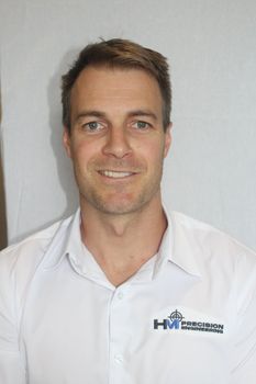 A man in a white shirt is smiling for the camera.