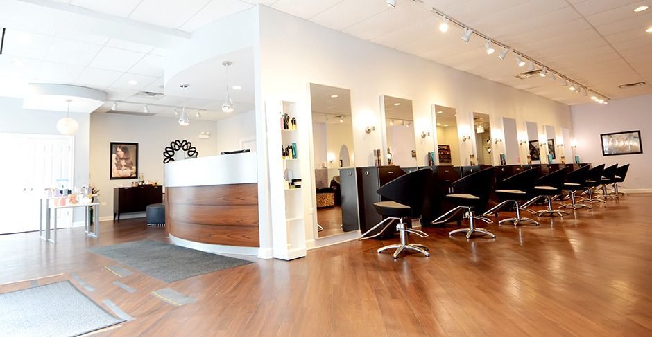 Modern hair salon interior with styling chairs, mirrors, and polished wood floor
