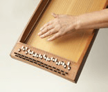 Eine Person spielt mit ihren Händen ein Holzspiel.