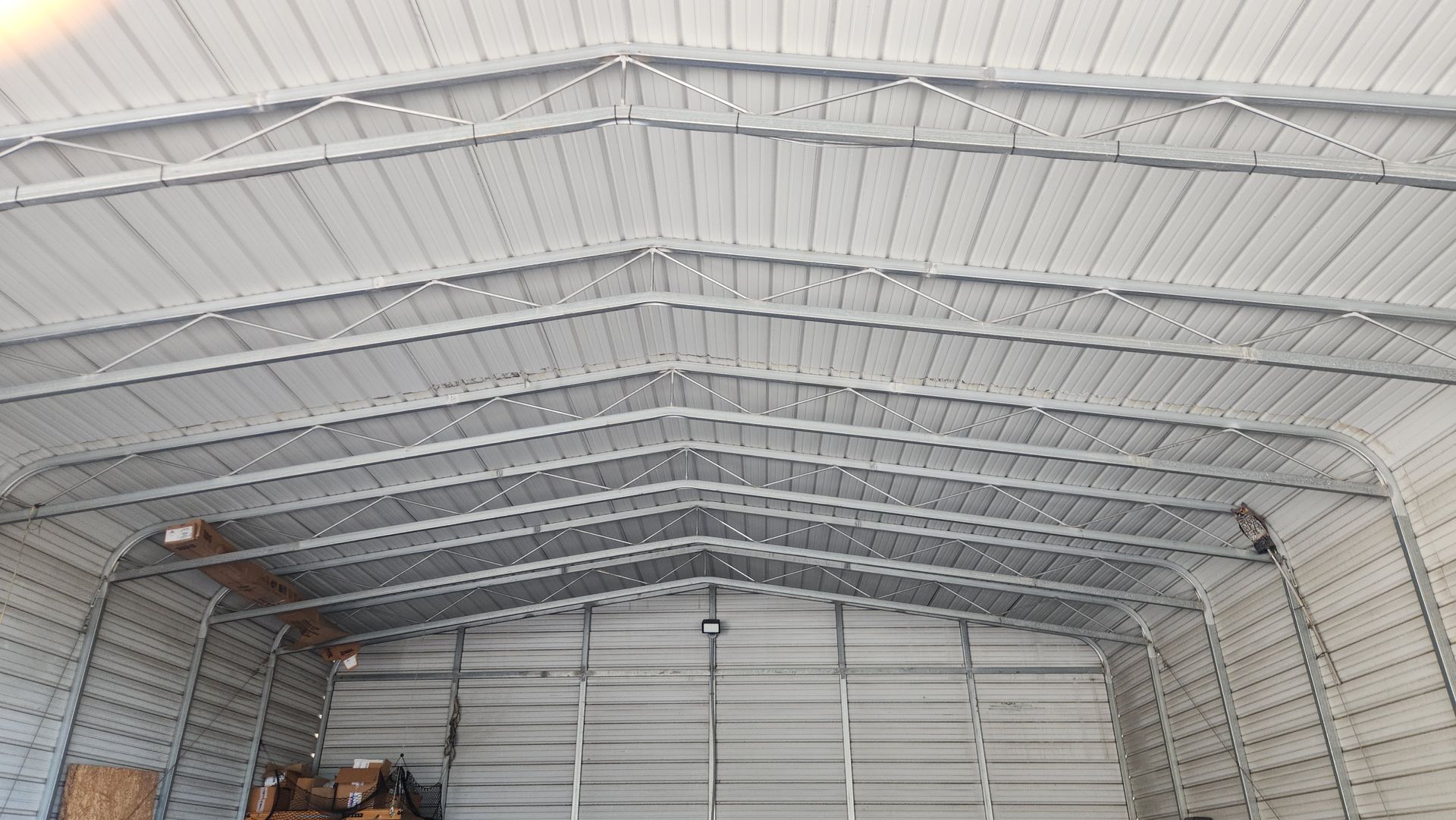 Interior view of a metal building with a ribbed ceiling and steel frame.