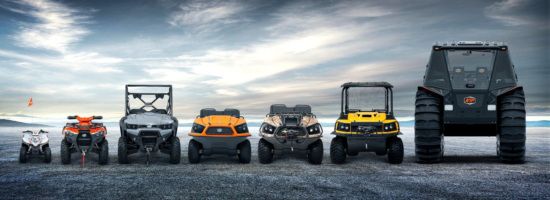 A lineup of six all-terrain vehicles, ranging from a small white quad to a large, black, multi-wheeled enclosed vehicle.