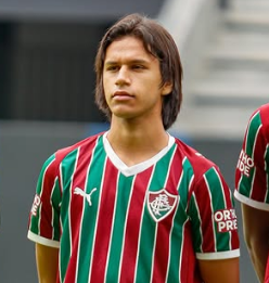 Jogador de camisa listrada verde e grana com linhas finas em branco com braços para trás olhando para frente