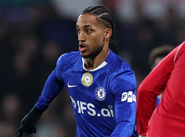 Um jogador de futebol com uma camisa listrada azul e branca está comemorando um gol.