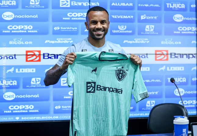 Um homem está segurando uma camisa verde com a palavra banpara escrita nela