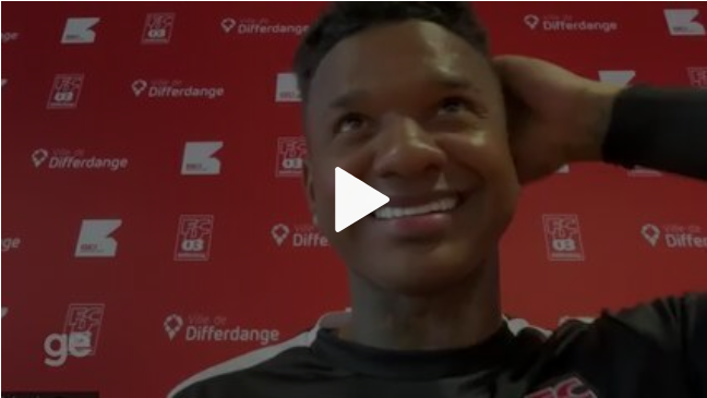 Um homem está parado em um campo de futebol ao lado de um manequim.