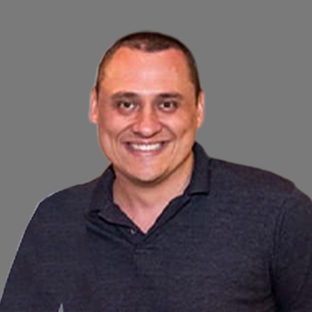 Um homem de camisa preta está sorrindo para a câmera.