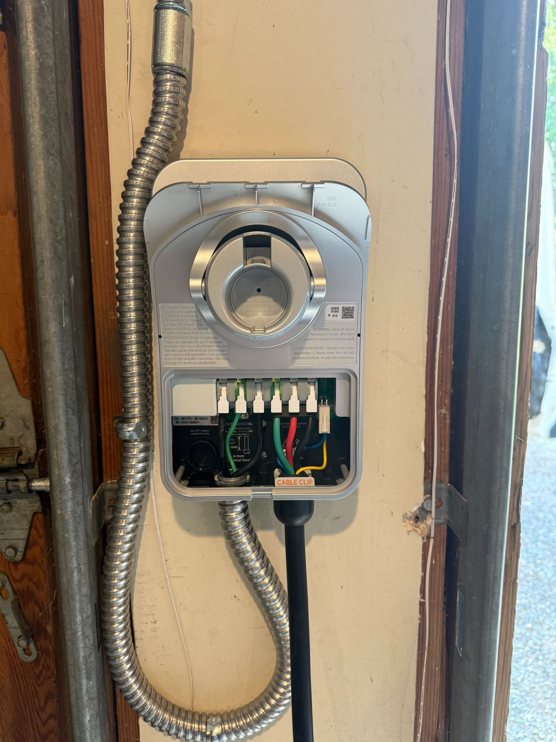 Open electrical meter box with wires and conduit on a wall