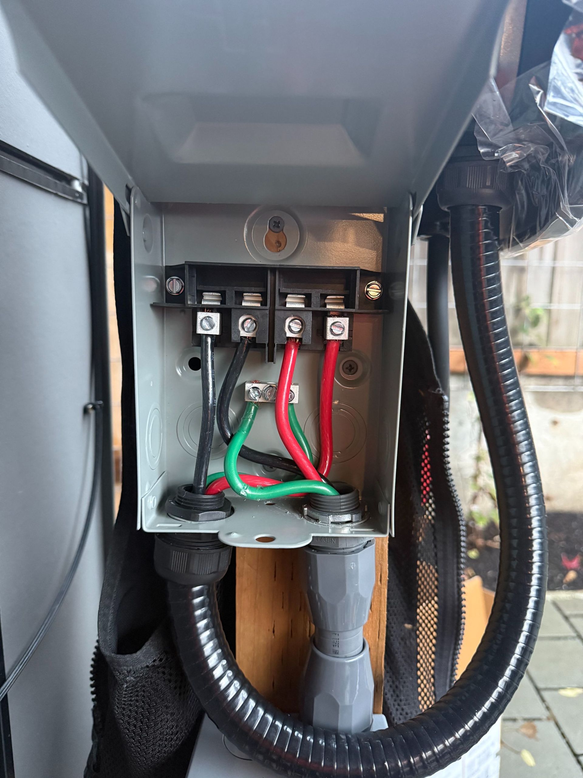 Open electrical panel with wiring, terminal blocks, and conduit inside a metal enclosure.