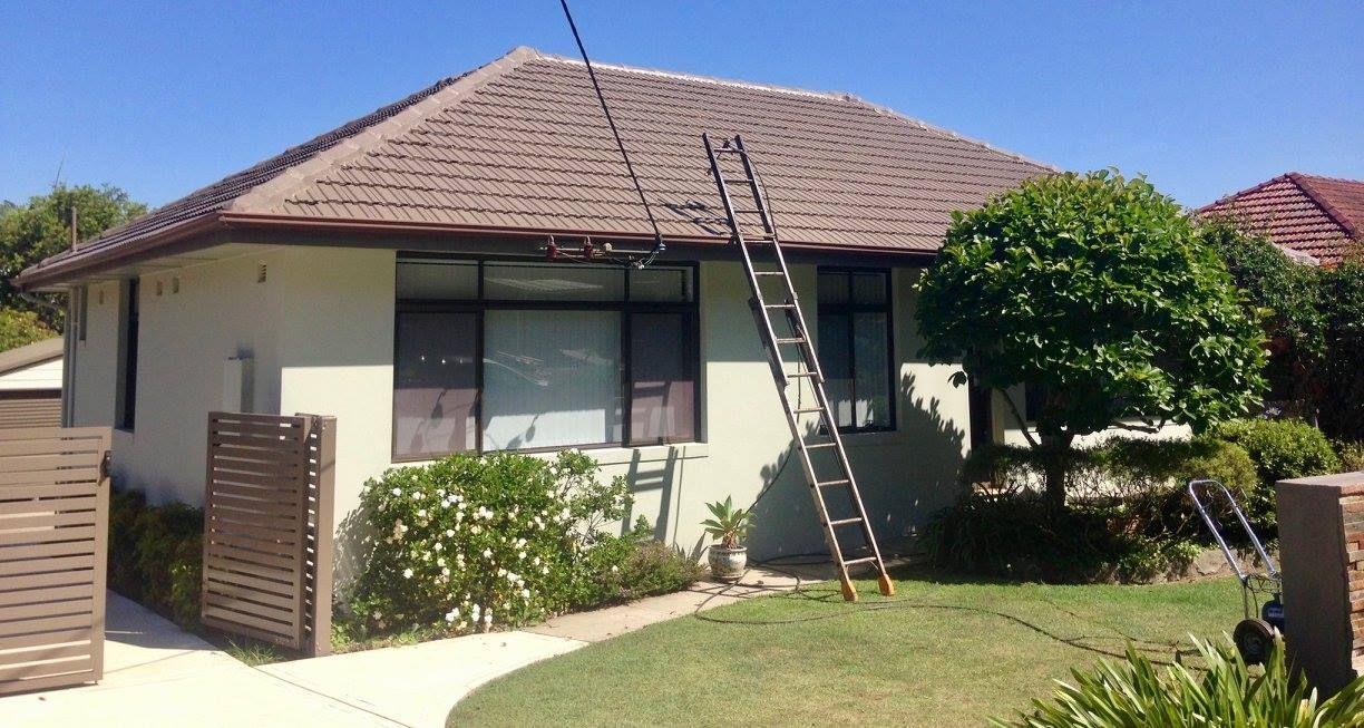 A House With A Ladder Hanging From The Roof — In-Time Roofing In Newcastle, NSW