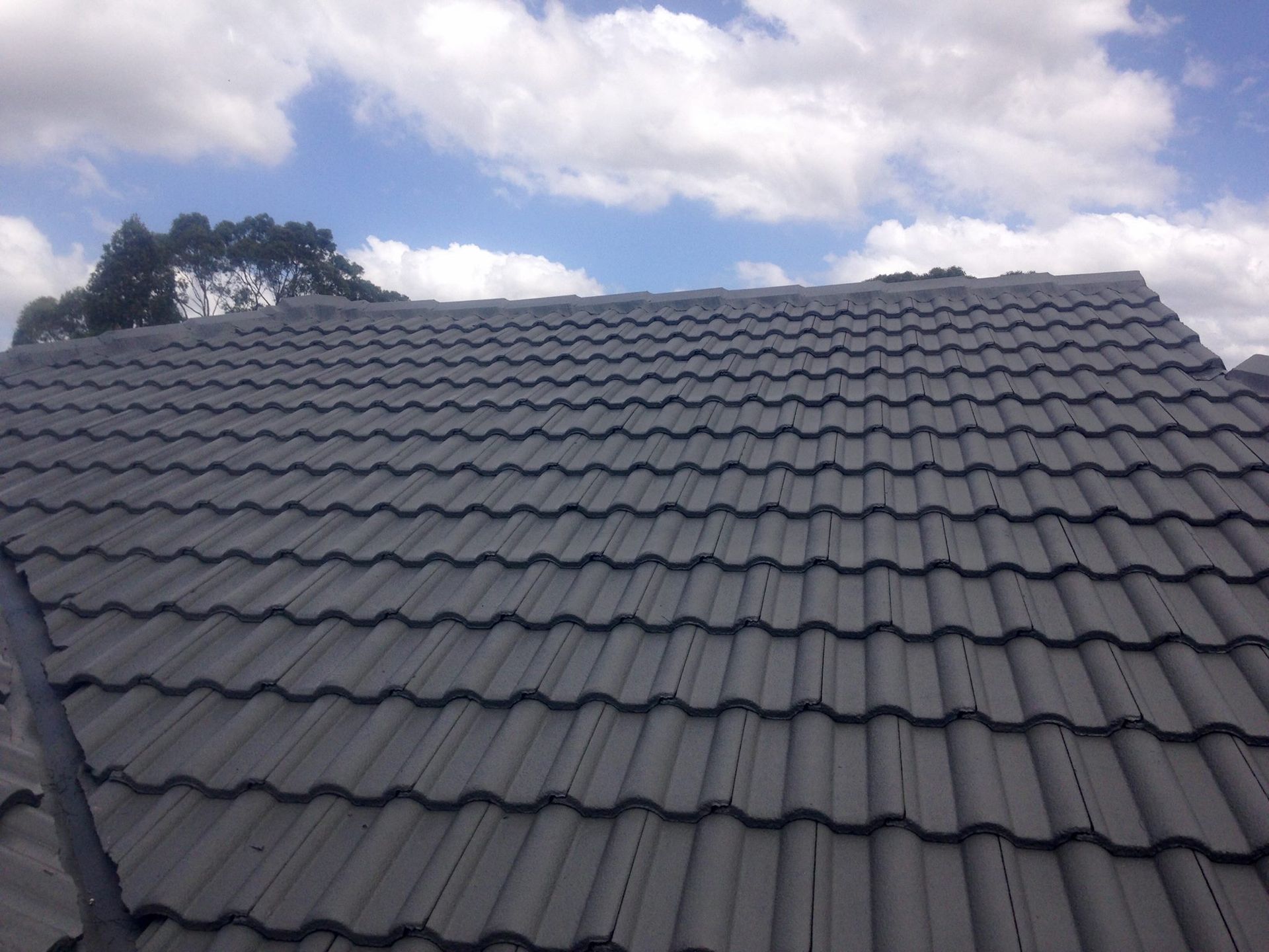 A Roof With A Blue Sky And Clouds In The Background — In-Time Roofing In Maitland, NSW