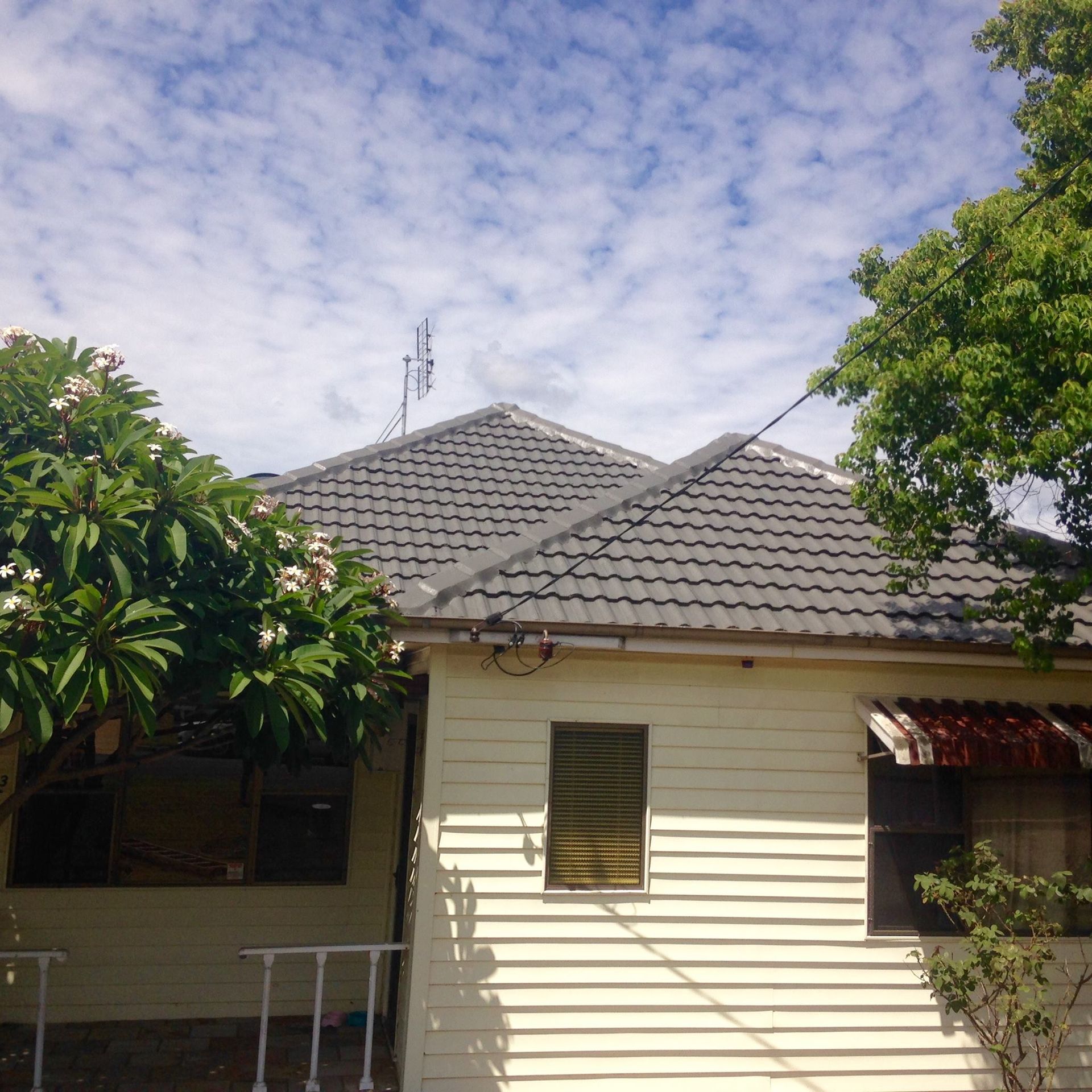A White House With A Gray Tile Roof — In-Time Roofing In Newcastle, NSW