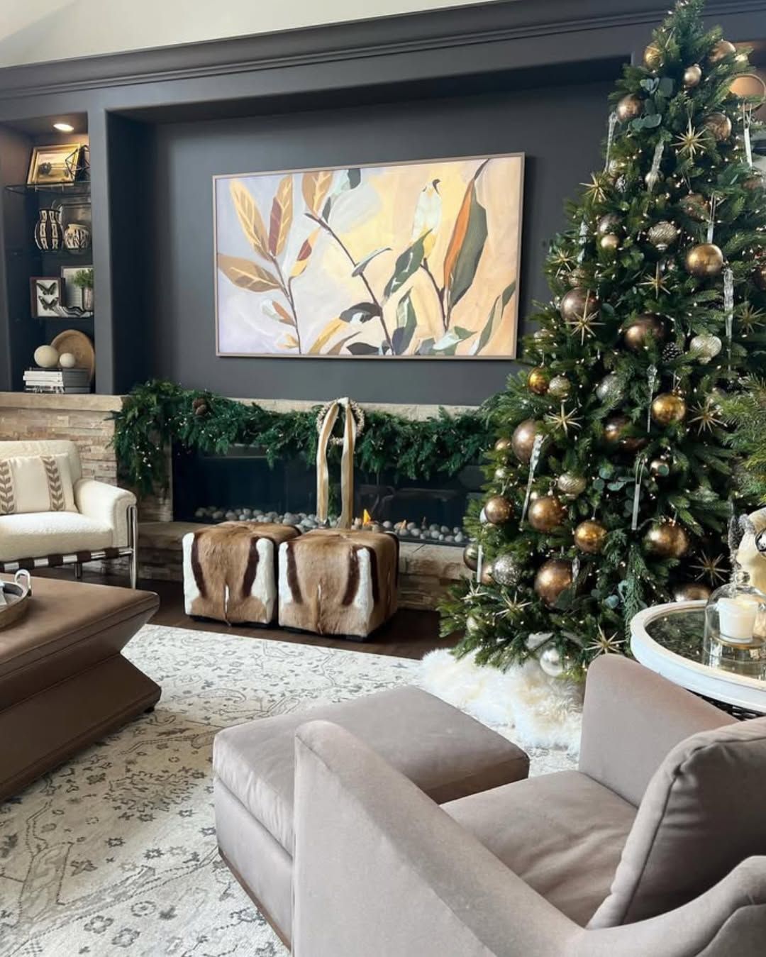 There is a christmas tree in the middle of the living room.