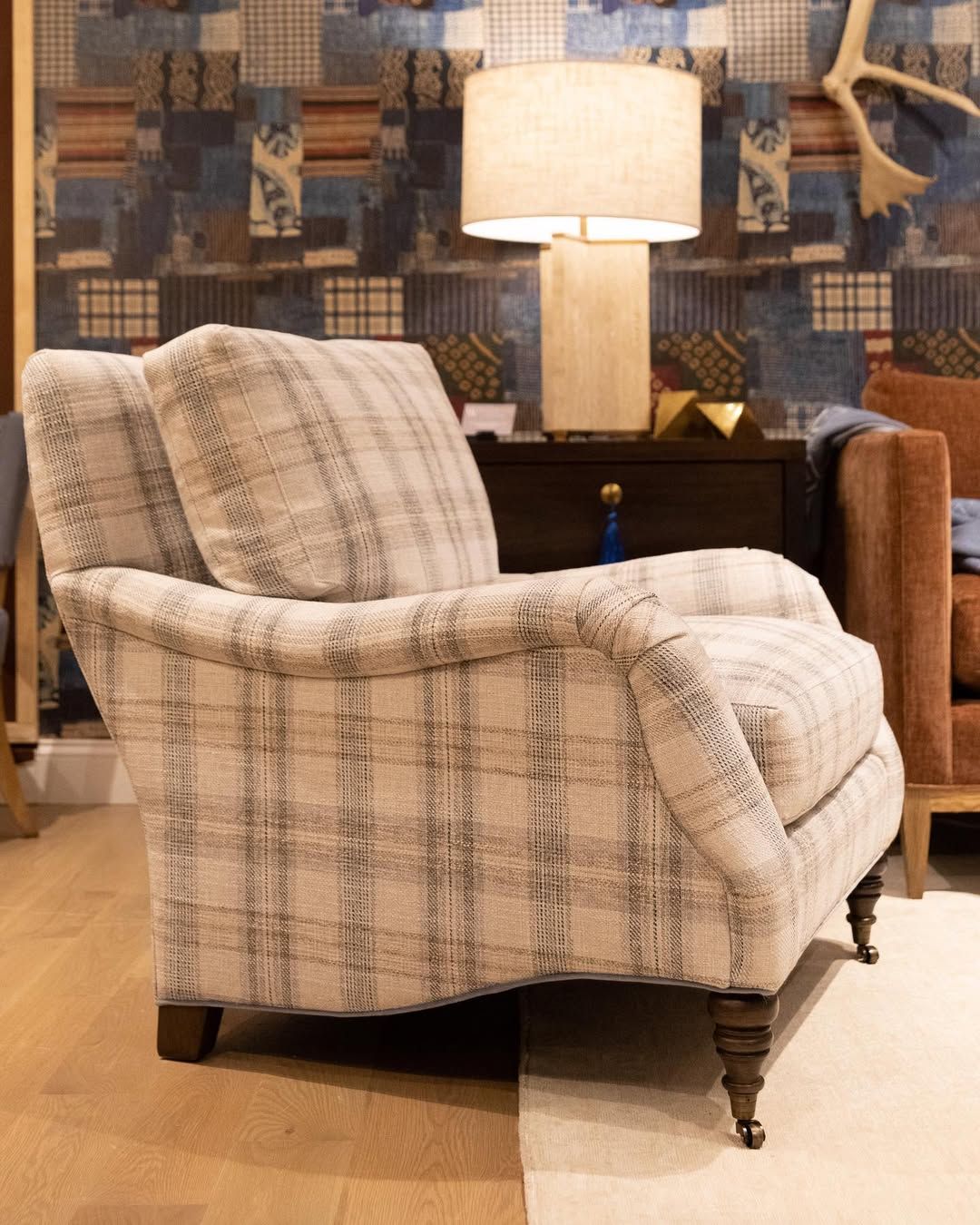 A chair is sitting in a living room next to a lamp.