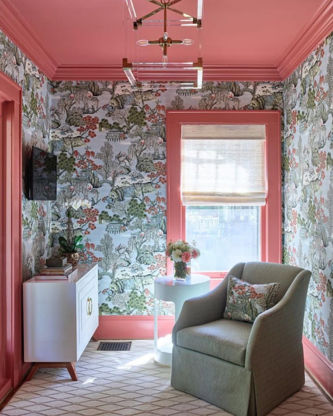 A room with pink walls and a chair and a table