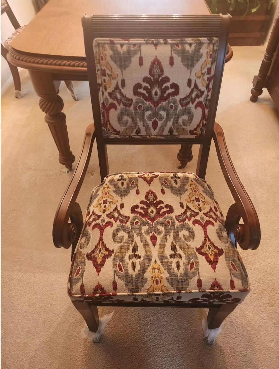 A chair with a floral pattern sits in front of a table