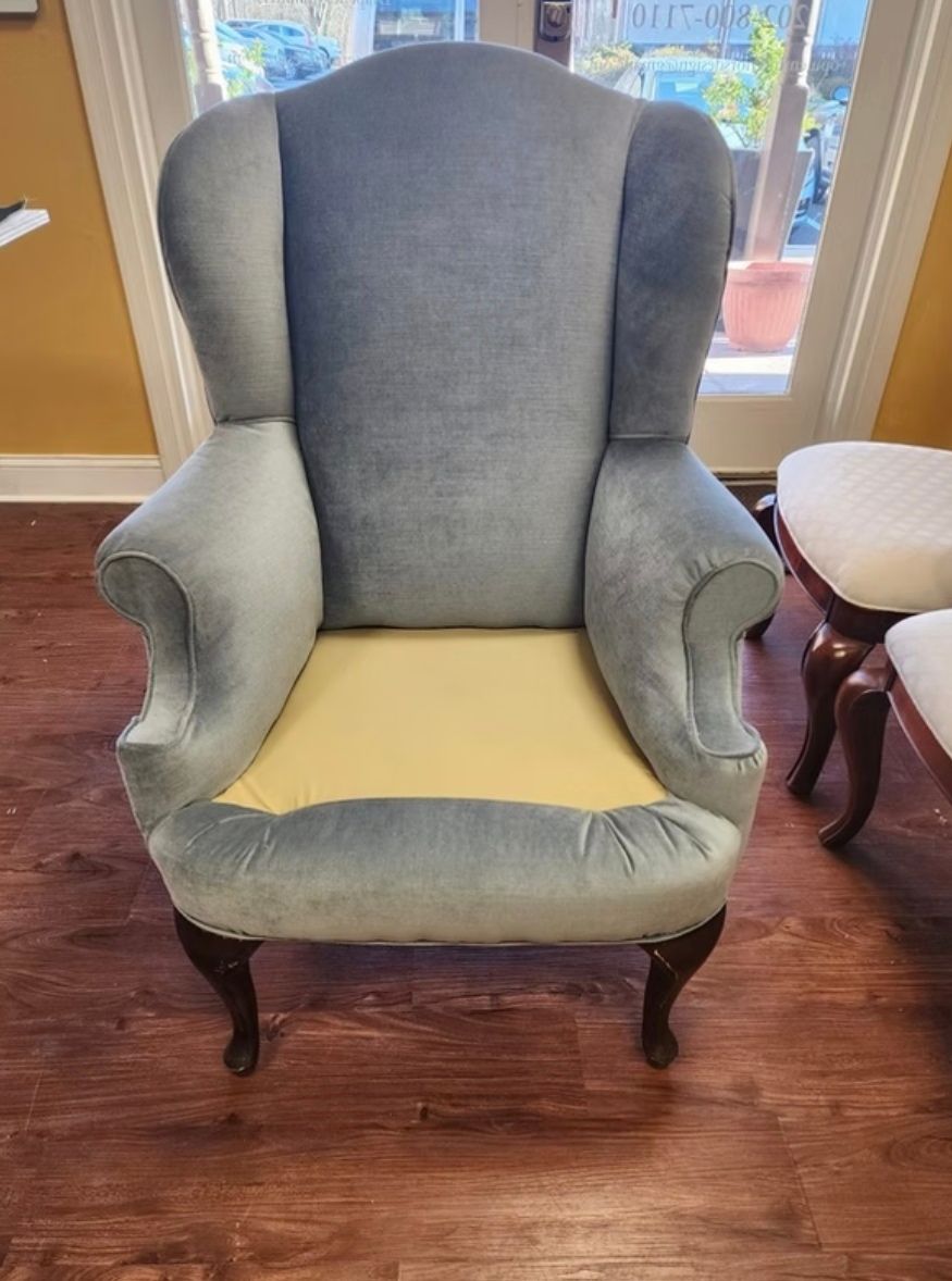 A chair is sitting on a wooden floor next to a window.