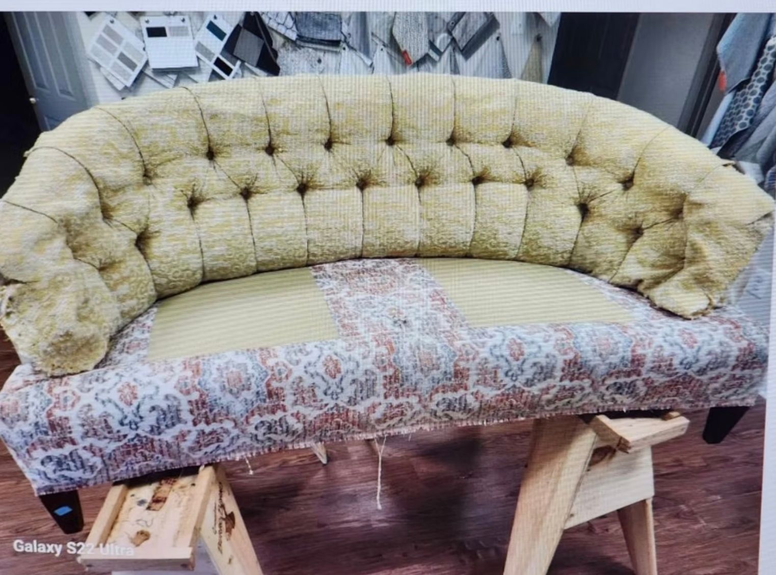 A couch is sitting on top of a wooden trestle.