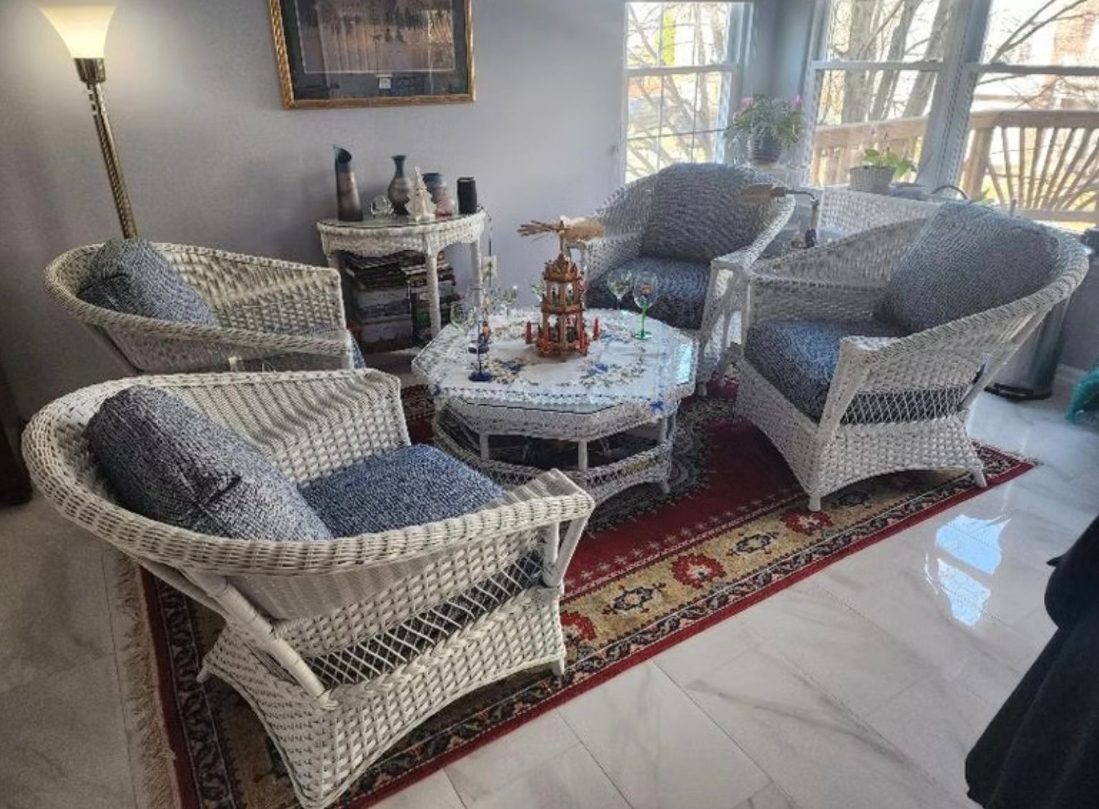 A living room with wicker furniture and a rug.